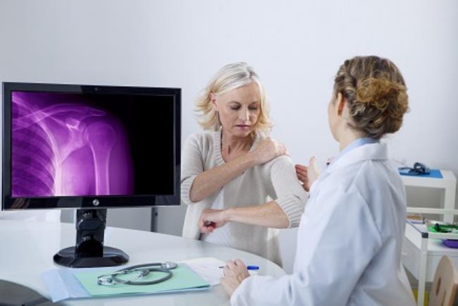 רופאה מאבחנת מטופלת באמצעות הדמיית רנטגן, ראלוקסיפן לטיפול באוסטאופורוזיס